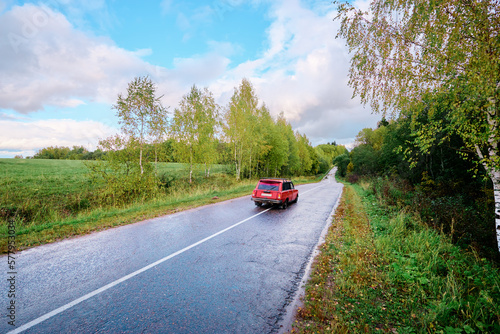 Fall season. Beautiful landscape with car on the road.