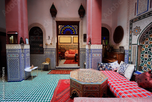 Oriental hospitality. Traveling by Morocco. Relaxing in festive moroccan traditional riad interior in medina. Comfortable terrace filled with soft, cozy furniture.