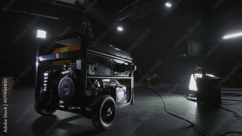 Black mobile gasoline power generator in a dark workshop. Gasoline powered  generator that produces light. Battery equipment connected by wires. Dark  empty room with light. Stock Photo | Adobe Stock