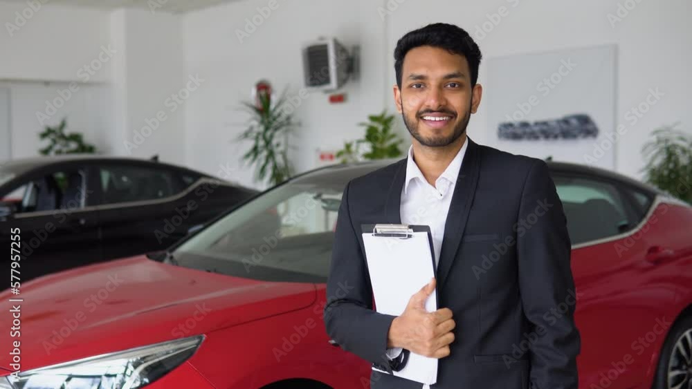 Portrait of a successful indian male manager in a car dealership, electric car sales Portrait of a successful indian male manager in a car dealership, electric car sales