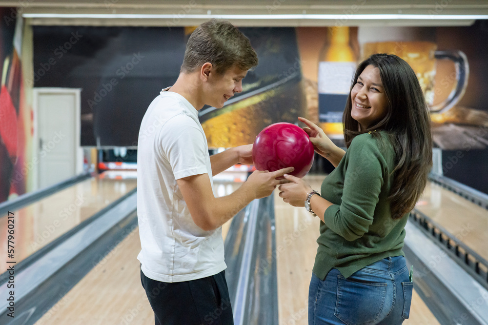 Obraz premium A guy and a beautiful and smiling girl bowling
