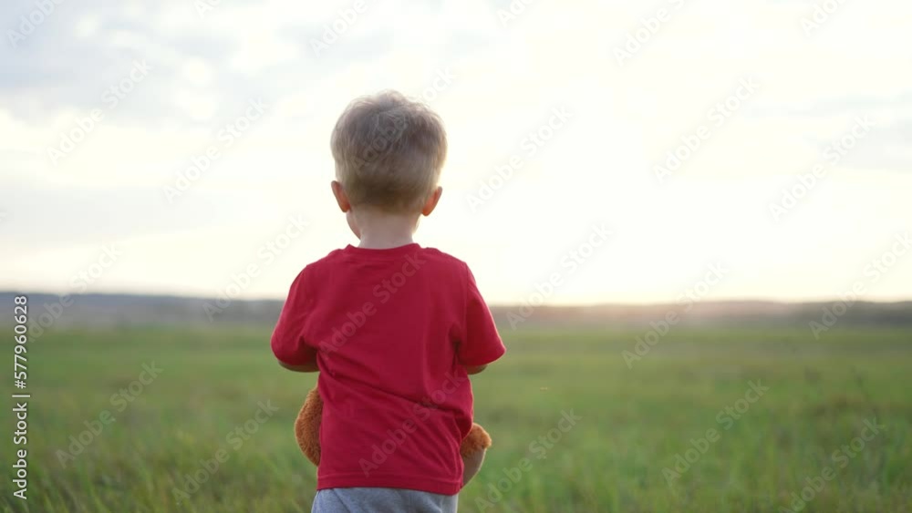 Sad lonely boy. Kid with teddy bear in park. Child on picnic. Boy on a picnic is playing with a toy. Brown teddy bear in hands of child. Sad lonely kid in the park. Children walk in the park at sunset Sad lonely boy. Kid with teddy bear in park. Child on picnic. Boy on a picnic is playing with a toy. Brown teddy bear in hands of child. Sad lonely kid in the park. Children walk in the park at sunset