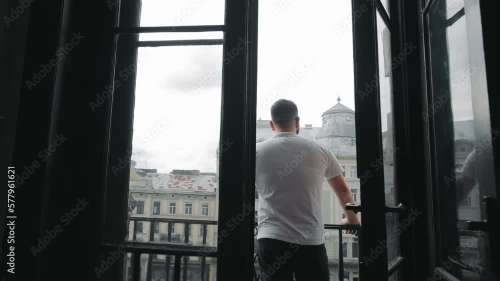 a man stands on the hotel terrace, rear view and looks at the city. Morning routine. a man stands on the hotel terrace, rear view and looks at the city. Morning routine.