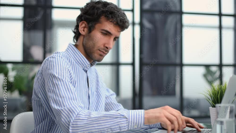 Young modern business man working using computer while sitting in the office. Young modern business man working using computer while sitting in the office.