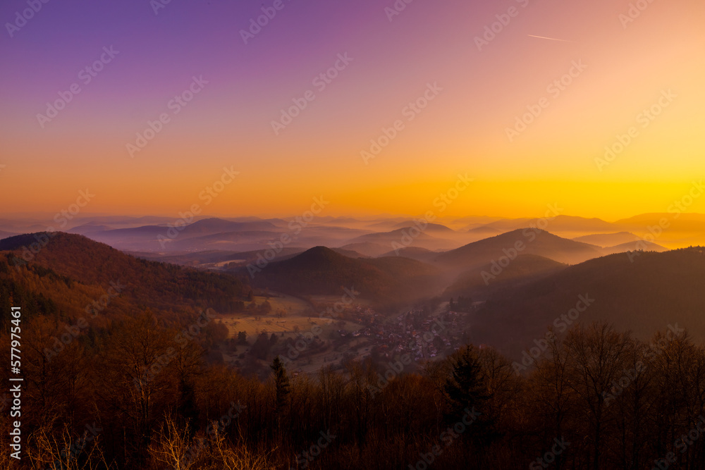 Sonnenaufgang und winterliche Hügellandschaft bei der Wegelnburg,  bei Schönau im Pfälzerwald in Rheinland-Pfalz, Deutschland, nahe der Grenze zu Frankreich. 