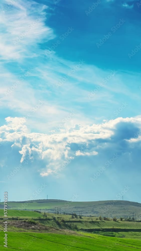 Timelapse, green rolling fields, clouds and sun rays, vertical short video, reel