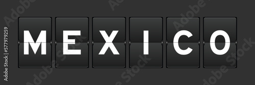 Black color analog flip board with word mexico on gray background