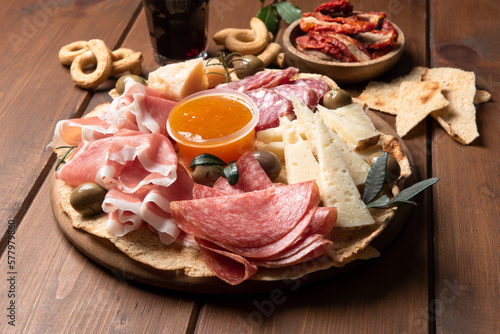 Tagliere con prodotti tipici della gastronomia italiana: salame, prosciutto crudo, pecorino, parmigiano, taralli e vino 