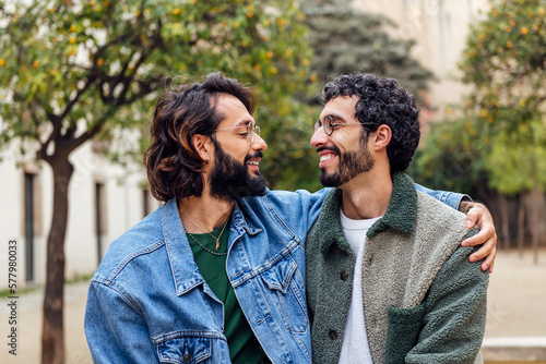 young couple of gay men looking into each other's eyes tenderly, concept of urban lifestyle and love between people of the same sex, copy space for text