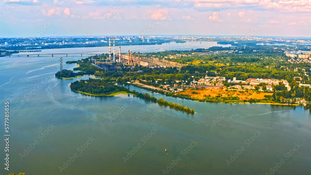 Photo from a drone of a beautiful summer landscape over the river. Beautiful summer landscape with a wide river and green coastline. Aerial photography of the suburban landscape.