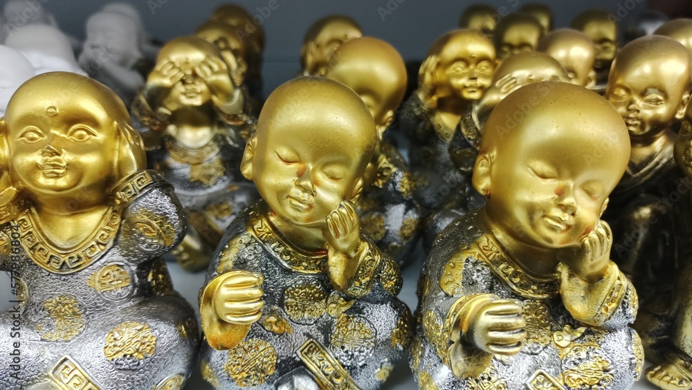 Fototapeta premium Golden statues of a boy who does not hear, does not see and touches his face with his hands