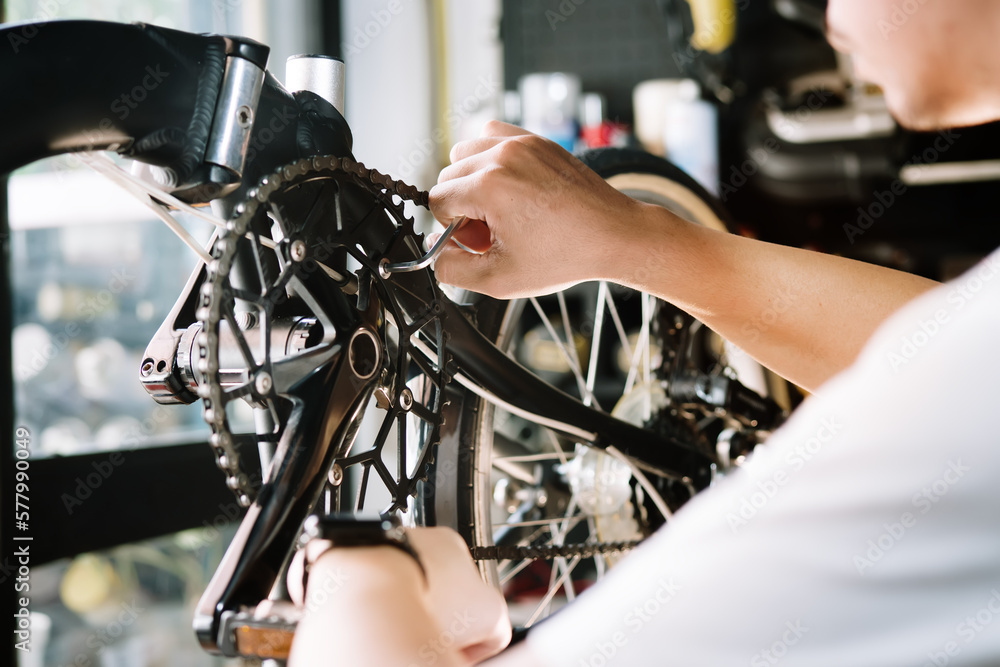 Fototapeta premium Technician makes adjustments to Crankset and repairing the gearshift on a folding bicycle working in workshop , Bicycle Repair and maintenance concept