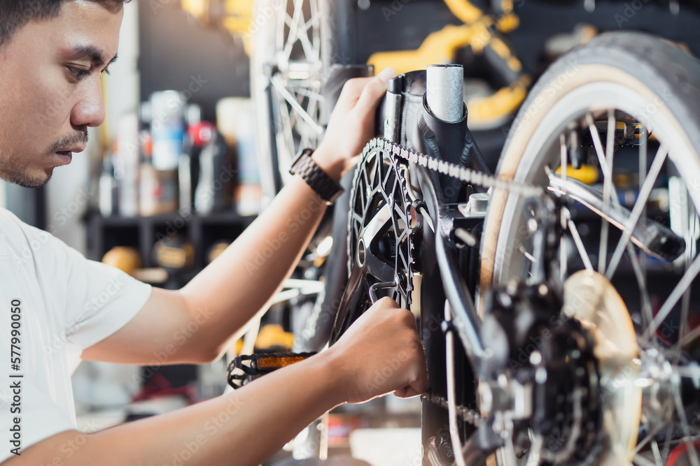 Technician makes adjustments to Crankset and repairing the gearshift on a folding bicycle working in workshop , Bicycle Repair and maintenance concept