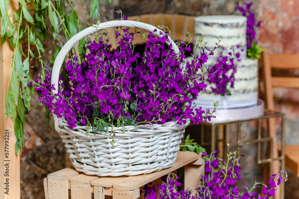 Close up of lavender flowers in basket on wooden box in front of the birthday cake in banquet hall