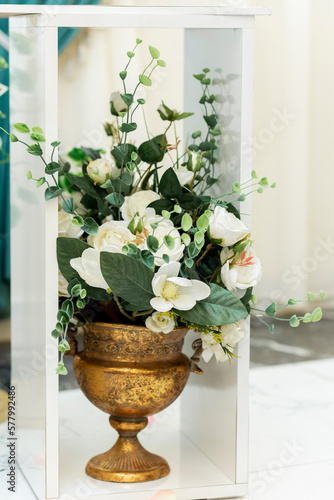 Obraz na płótnie Closeup of wedding ornament. Artificial white flowers in metal vase on the floor in banquet hall w salonie