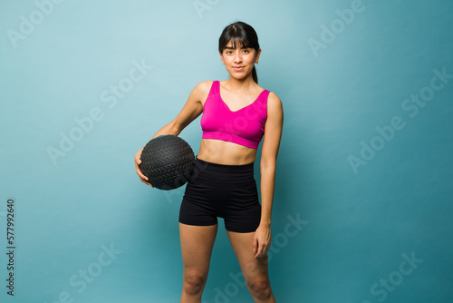 Sporty young woman with a slam ball exercising © AntonioDiaz