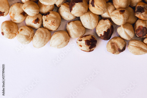 Peeled hazelnuts on a white background. Poorly peeled hazelnuts. Background of peeled hazelnuts.