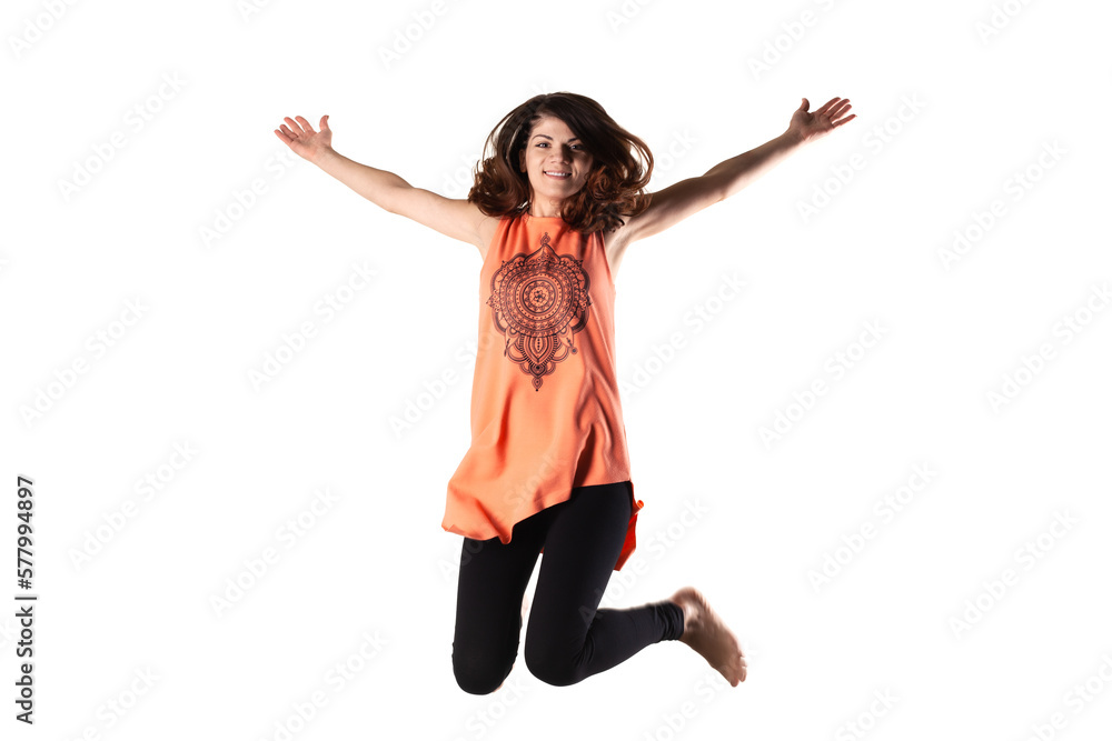 happy brunette girl in orange outfit jumping in the air against white background