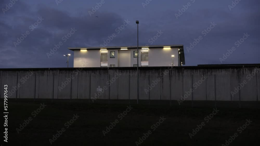 A prison with high concrete walls and barbed wire.
A prison with high concrete walls and barbed wire.
