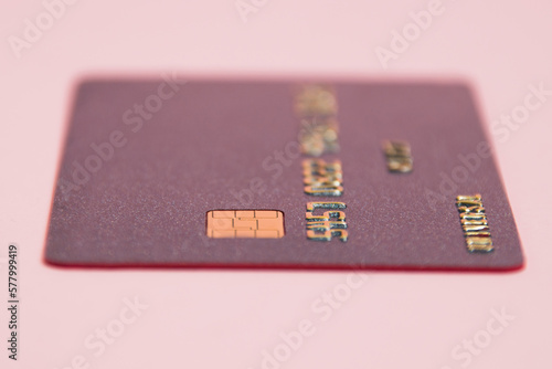 Bank card with chip macro on pink background. Modern technologies of payment for goods in the store and online