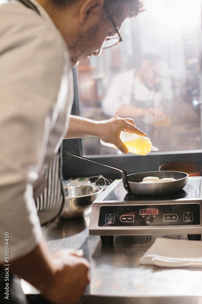 Сooking food, profession and people concept - male chef cook with frying pan at restaurant kitchen.. Сooking food, profession and people concept - male chef cook with frying pan at restaurant kitchen..