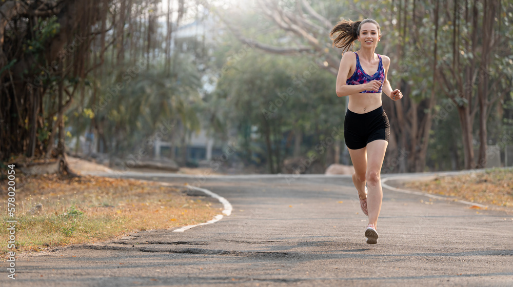 young attractive woman running in the park at morning.