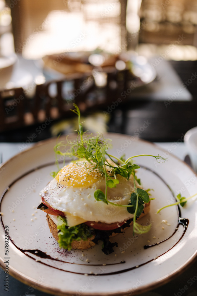 Salmon on a pillow of tomato on toast, and a poached egg on top, garnished with black sesame, spirulina and microgreens Salmon on a pillow of tomato on toast, and a poached egg on top, garnished with black sesame, spirulina and microgreens