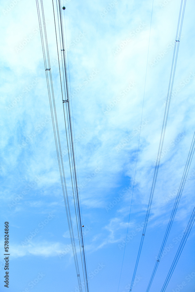 Bottom view of the blue sky with wires. For background, wallpaper, digital artwork use and etc.. Rural scene