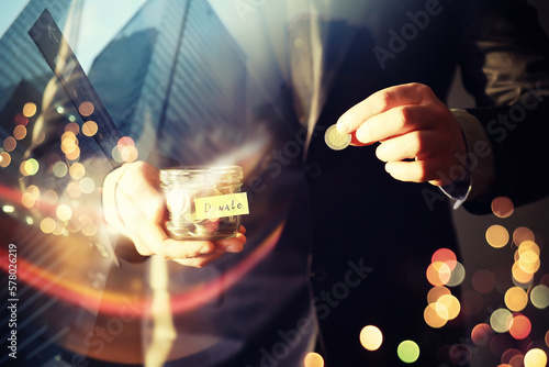 Businessman hand putting money (coin) in the glass jar, vintage tone effect. double exposure skyscraper