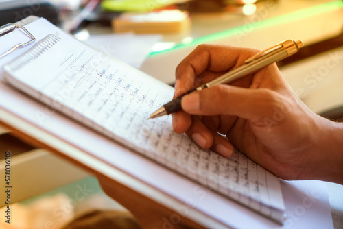 World Letter Writing Day image, young men writing on notepad, proofreading concept image photo