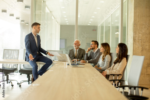 Young businessman presenting results to his coleagues in the office photo