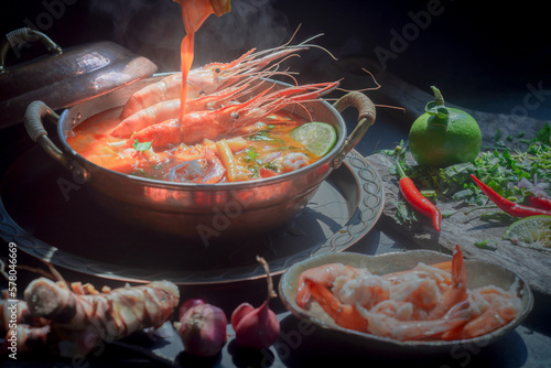 Tom Yum Goong Thai hot spicy soup shrimp with lemon grass,lemon,galangal and chilli on  top view on dark backgroundThailand Food photo