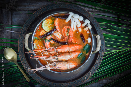 Tom Yum Goong Thai hot spicy soup shrimp with lemon grass,lemon,galangal and chilli on  top view on dark backgroundThailand Food photo