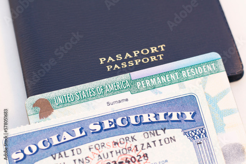 United States passport, social security card and permanent resident (green) card on white background. Immigration concept	 photo