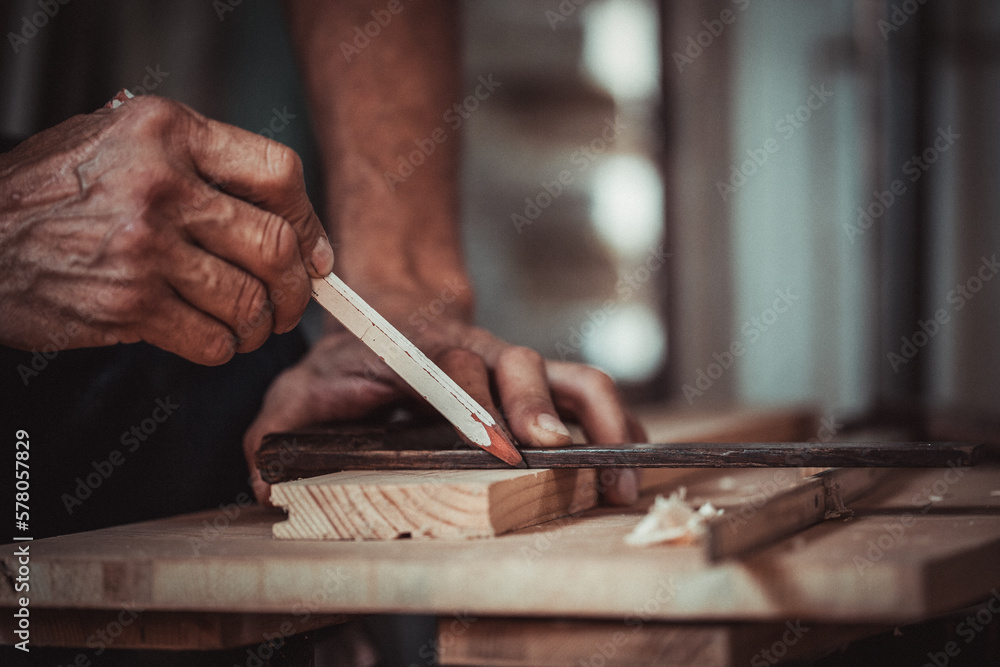 Carpenter using working tools while working on a wood in carpentry workshop Carpenter using working tools while working on a wood in carpentry workshop