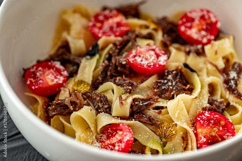 Fototapeta premium Tagliatelle with stewed veal with truffle paste, cheri and parmesan. Pasta with veal