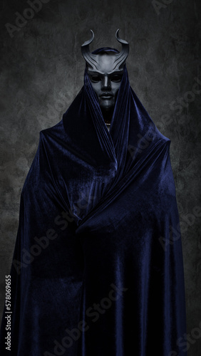 Studio shot of follower of dark cult dressed in dark robe and horned mask.