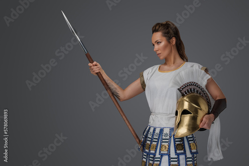 Studio shot of isolated on gray background soldier woman from antique greece.