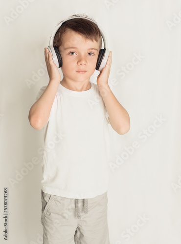 smiling little boy with headphones at home