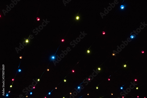 Multicolored lights bulbs on black night sky Background