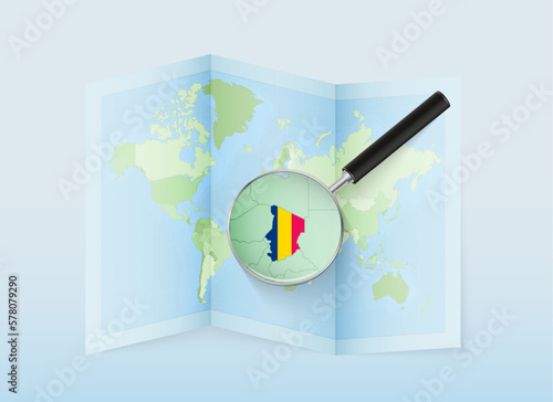 A folded world map with a magnifying lens pointing towards Chad. Map and flag of Italy in loupe.