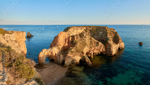 Small islet and grotto near Praia Joao de Arens in Alvor, Algarve region photo