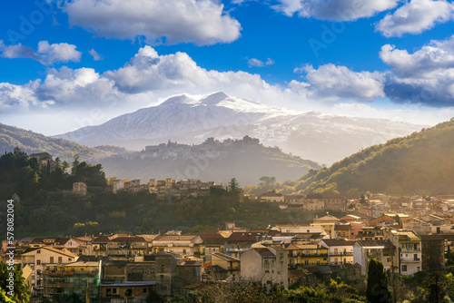 highland travel landscape, scenic view to a beautiful mountain town in sunrise or sunset with snow on top of mountains on background and amazing colorful sky