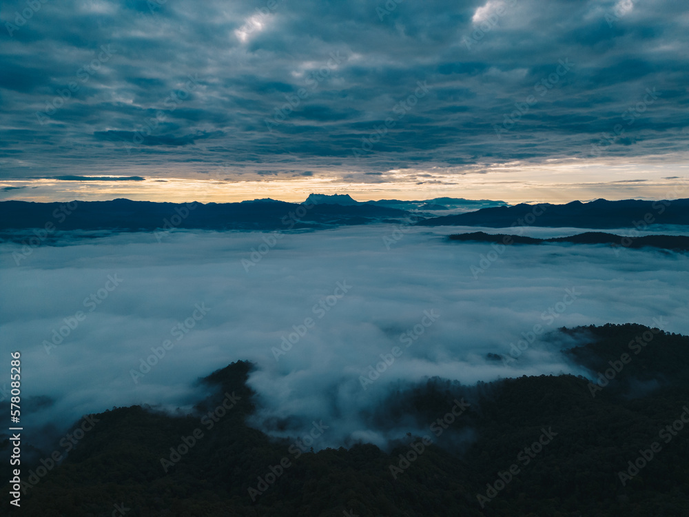 Mountain range and mist with sky and sunrise and surrounding area.