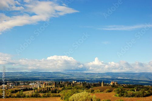 View of medieval town of Carcassonne through vines and fields. Languedoc, Occitania, France. Travel background.