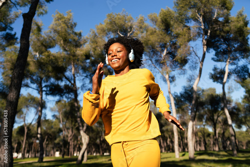 A girl in a yellow tracksuit jogs in the park
