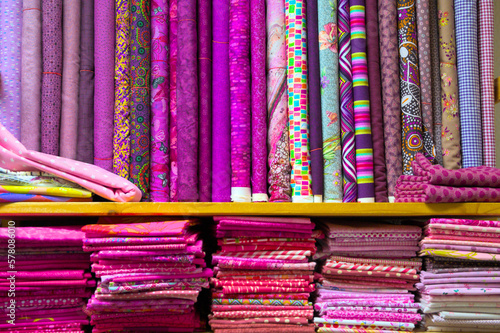 colorful red, purple, pink and orange textile fabrics for sale in a shop