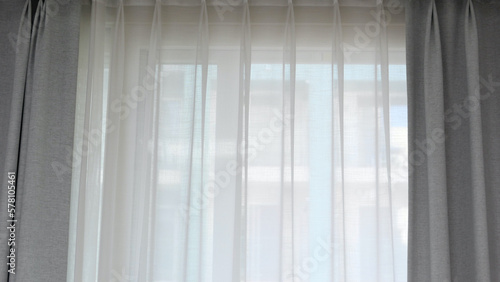 Voile curtain in front of window with grey curtains to either side
