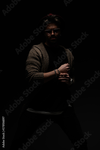 male model in a tough stance fixing his bracelet