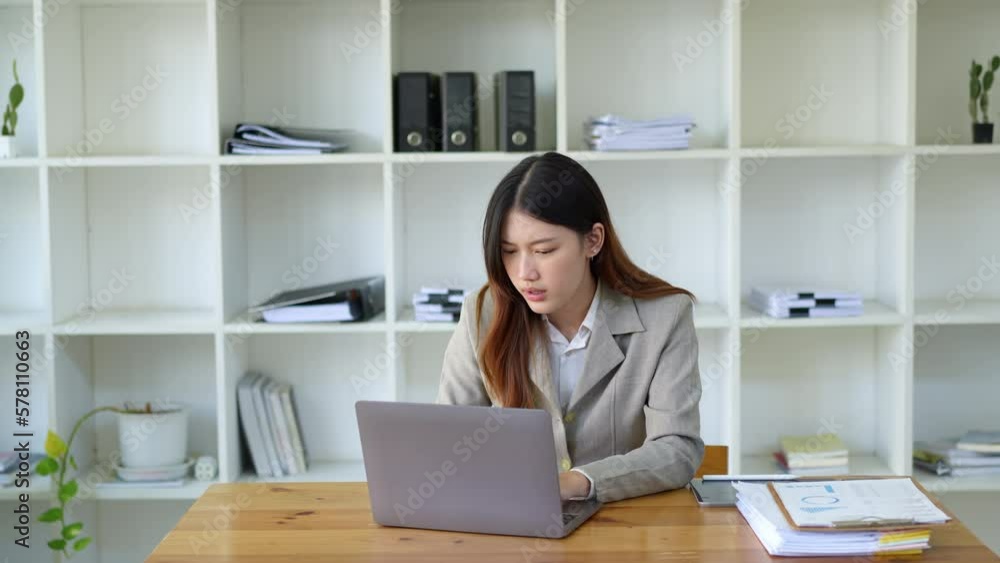 Portrait of business owner, businesswoman using computer and financial statements Anxious expression on expanding the market to increase the ability to invest in business. Portrait of business owner, businesswoman using computer and financial statements Anxious expression on expanding the market to increase the ability to invest in business.